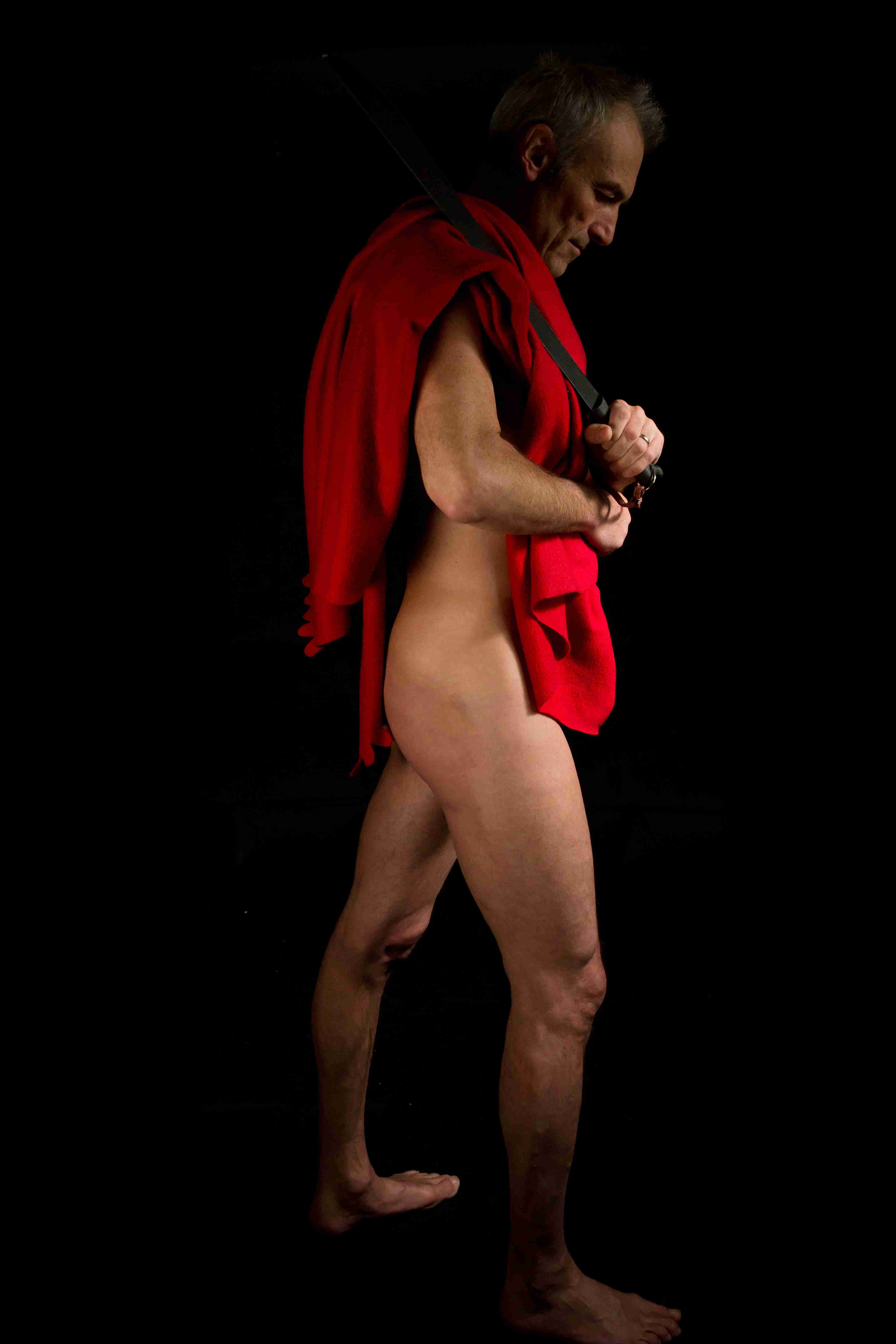 life model Julian, carrying a red coat and black belt for an artist to draw or sculpt